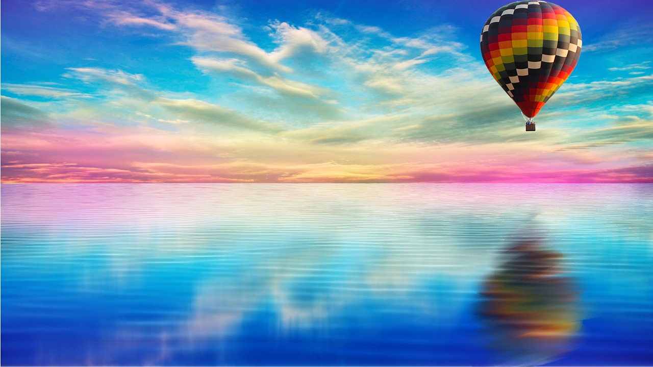 reflection of hot air balloon over water