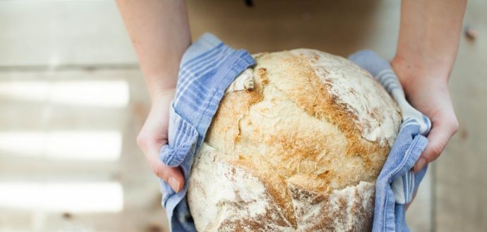 freshly baked bread wrapped in a blue kitchen towel