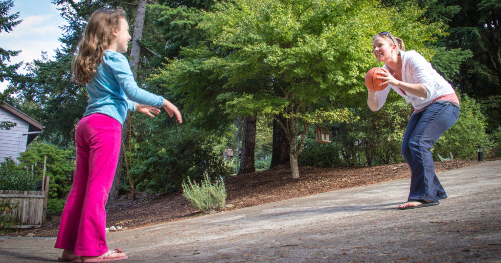 child playing a game with a basketball with adult