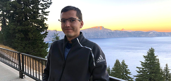 male student with glasses near river