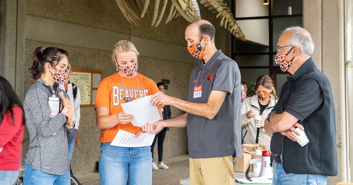 Oregon State scientists and students overview instructions for TRACE project, all wearing masks