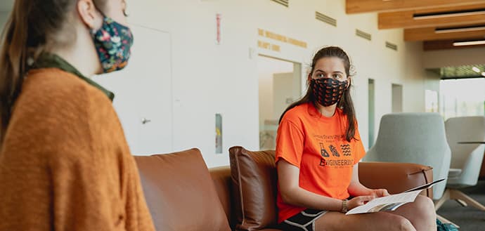 students wearing beaver nation face masks study in common area during fall semester
