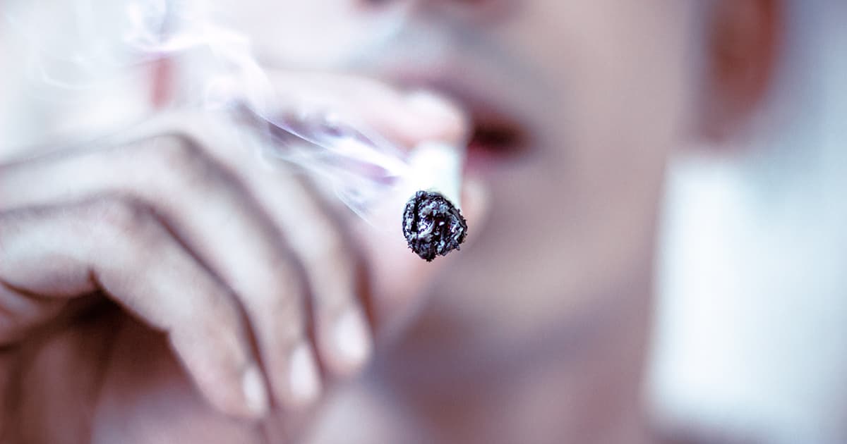 close up of a man smoking a cigarette