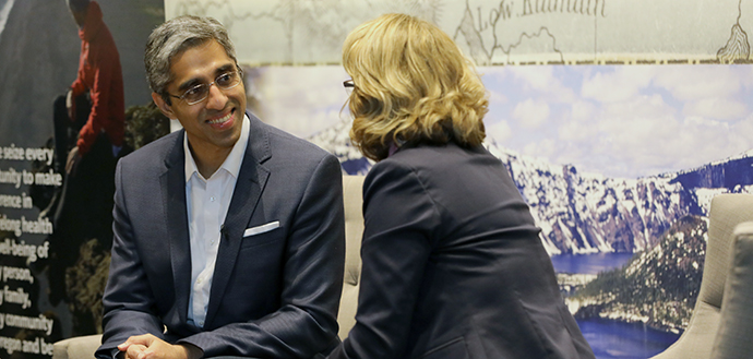 Vivek H. Murthy, MD smiles while sitting and talking to a woman