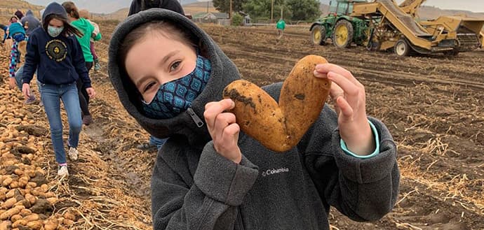 Young girl holds a potato shaped like a heart