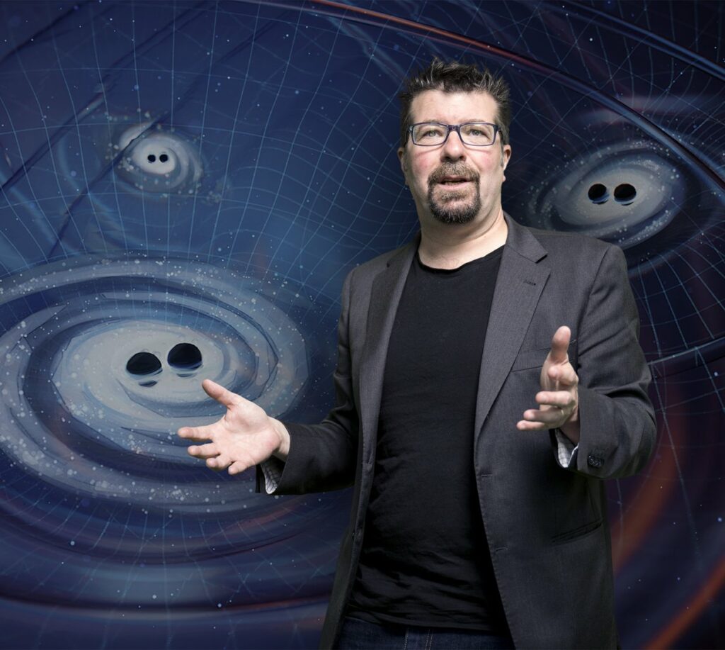 Photo of Xavier Siemens with a LIGO backdrop