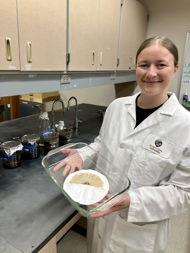 Fig. 11: Anna Perry holding a dish containing filter paper with MP, bleached OM, and some sediment