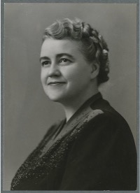 Black and white portrait of a white woman with styled hair and a slight smile.