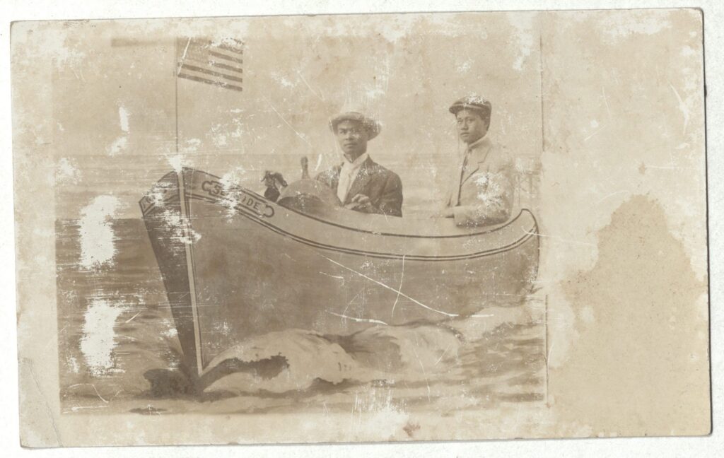 Postcard photograph, two men in a prop boat