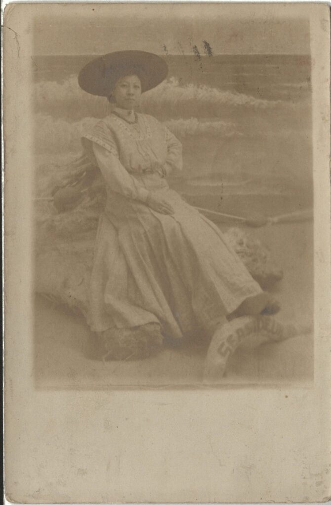 Postcard photograph, a portrait of a woman in an a prop beach setting