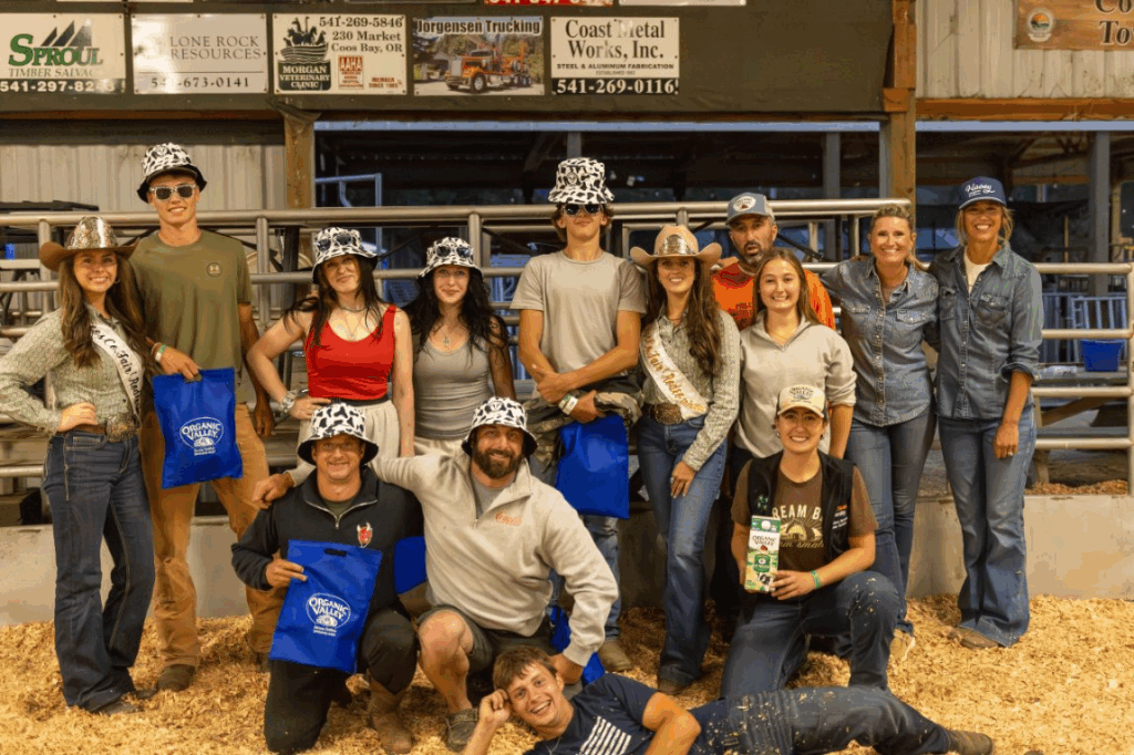 A group of 14 people holding awards, some are wearing cow print bucket hats.