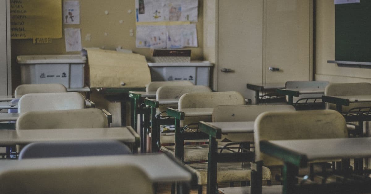 An elementary classroom with empty chairs and desks.