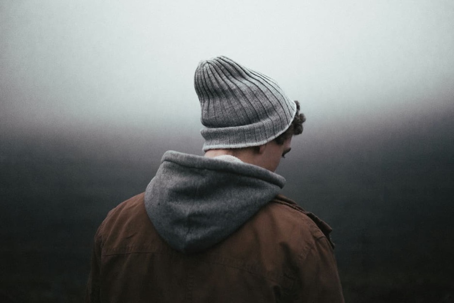 A teen wearing a beanie looking into the distance