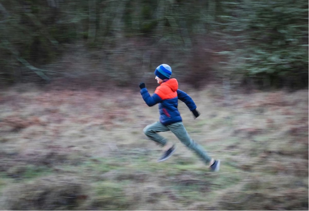 A child runs through a field.