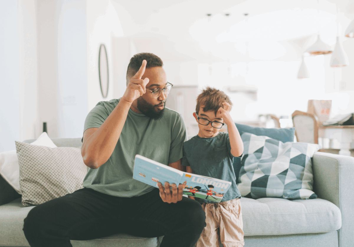 An adult signs as they read a book with a child.