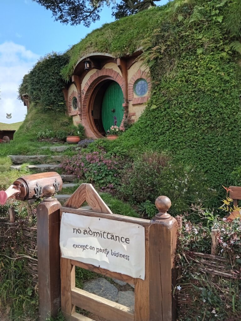 A hobbit hole with a sign prohibiting admittance, unless for party business.