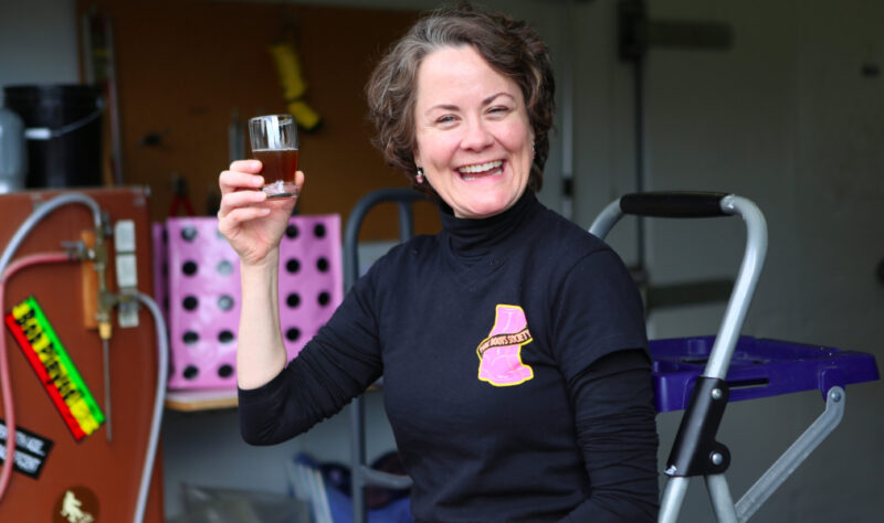 A woman holding a glass of beer
