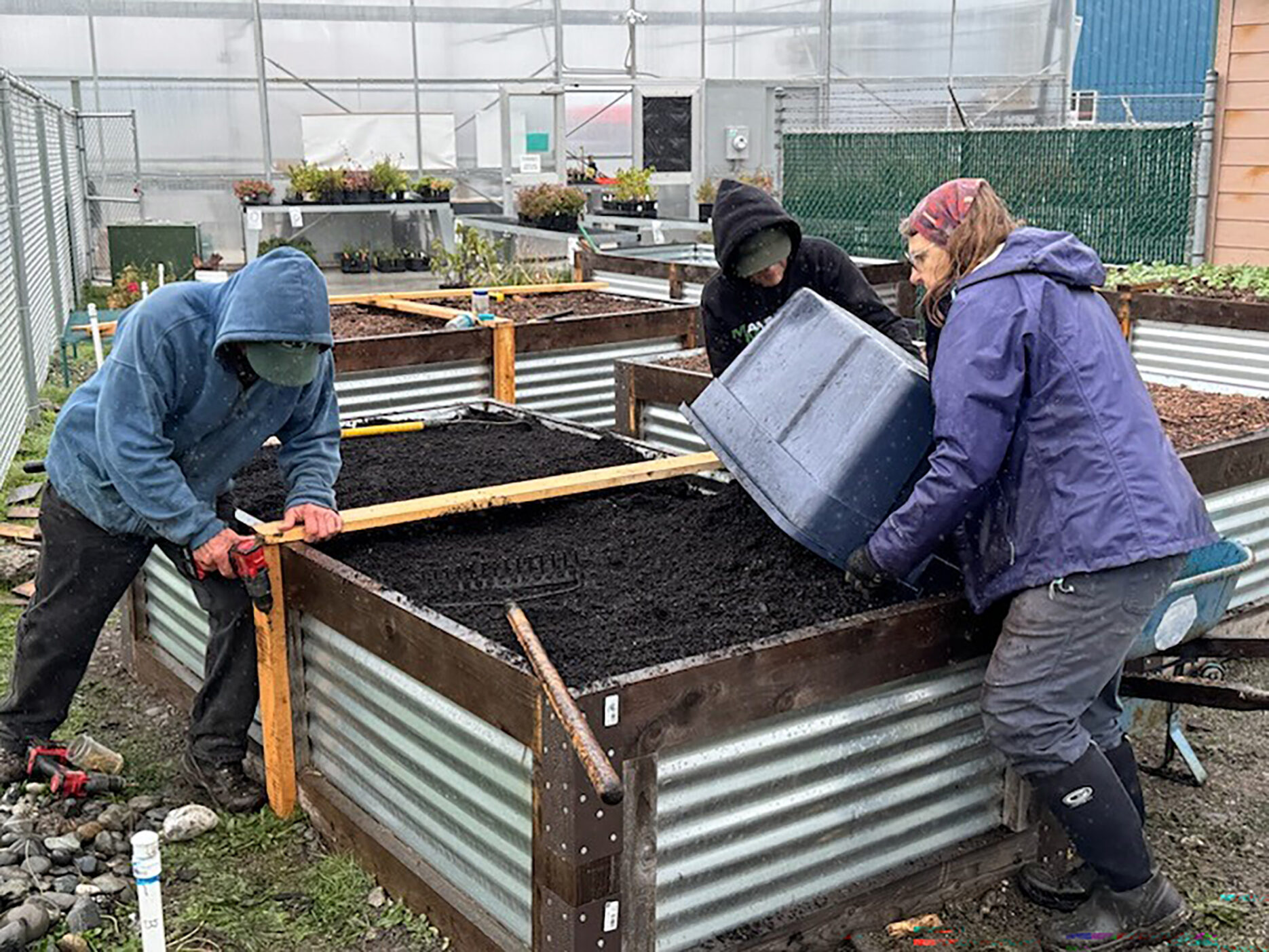Volunteers building Hügelkultur garden beds by Sarah Mocas