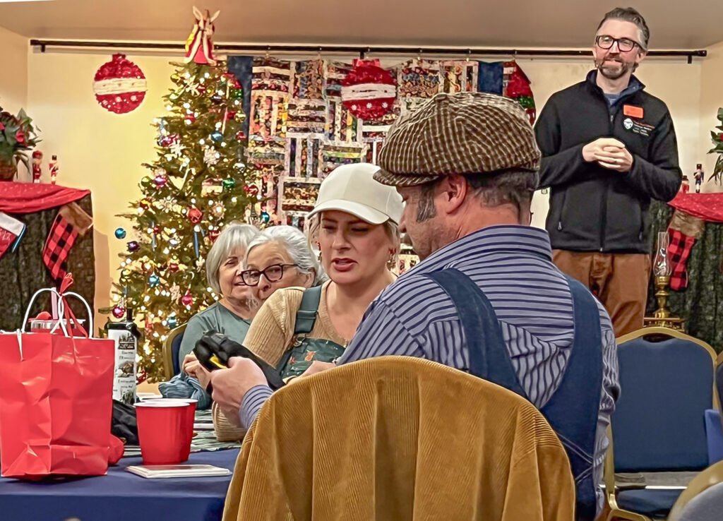 MG volunteers picking our their white elephant gifts at the 2025 holiday party by Jefferie Hall
